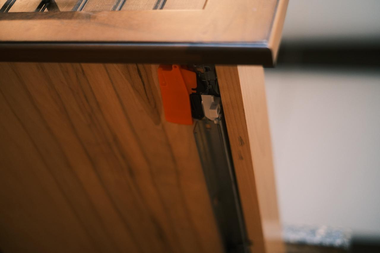 Undermount drawer slide and release mechanism under an open drawer